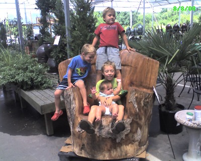 My children, showcasing one of our handcarved pieces at Pike's Nursery.